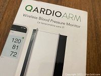 Box with QardioArm Wireless Blood Pressure Monitor branding and product image.