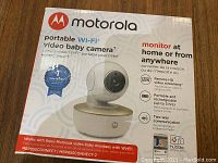 Box of Motorola portable Wi-Fi video baby camera with product and feature details visible on front.