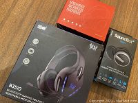 Photo showing the three headphone boxes including B3510 gaming headset, MPOWH919PO ANC wireless headphones, and SoundBot SB221 headphones.