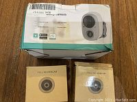 Photo of the smart video camera packaging and two closed boxes labeled Full HD Webcam