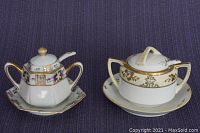Two vintage Nippon lidded salt cellars with their matching plates and spoons, showing front and detail of gold trim and hand paint on purple textured background.