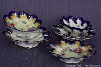 Five unique hand-painted Nippon porcelain candy or nut bowls stacked to show edges and patterns.