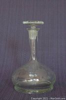 Front view of clear glass ship's decanter showing etched floral pattern and original stopper in place.