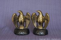 Front view of the pair of American eagle bookends showing gold finish and black base