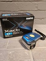 Sanyo Xacti VPC-E2 waterproof digital movie camera with original box showing model number and branding