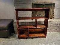 Front view of hand-made pine stained bookshelf showing all shelves and compartments