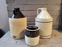 Three ceramic crocks arranged together: two one-gallon crocks and one smaller quart crock, showing overall appearance and condition.