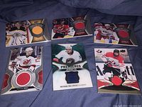 Clear overview of all 6 hockey game jersey cards arranged on cloth background.