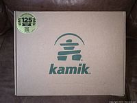 Closed Kamik cardboard shoebox with 125 years heritage logo for the brand.