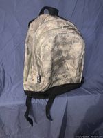 Front view of kids backpack in digital camouflage print showing main and secondary zippered compartments and black base.