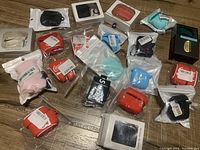 Overview photo showing multiple new AirPods cases in assorted colors and packaging laid out on floor.