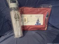 Photo of silver water bottle branded BROS and pink yoga mat bag wrapped in plastic