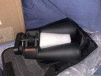 Photo of Celestron binoculars inside carrying case showing the textured focus wheel and eyepieces.