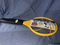 Full view of yellow and black tennis racket bug zapper with label and packaging intact.