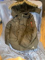 Padded brown kids Michael Jordan winter jacket with fur-lined hood and multiple pockets.