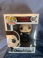 Front view of Stranger Things Eleven Elevated Funko Pop in original box showing figure and branding.