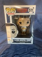 Front view of Eleven (Hospital Gown) Funko Pop in original box showing figure holding fries and box details.