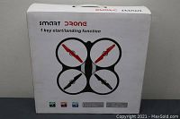 Photo of the front of the white drone box displaying quadcopter image and branding 'SMART DRONE' with 1 key start/landing function text.