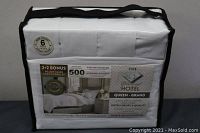 Packaged white microfiber sheet set with black trim zipper bag.