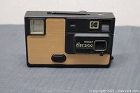 Front view of Kodak Disc 3100 camera showing wooden panel design, flash, viewfinder, and lens with branding.