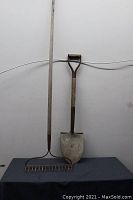 Full view of the shovel and rake side by side showing their condition and size relative to each other.