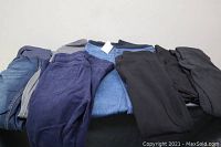 Photo showing six pairs of maternity pants in various colors and styles laid out on a surface.