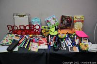 Wide view of stationery lot showing various pens, markers, highlighters, sticky notes, books ends, pencil holders and other items.