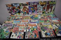 Full spread of 21 vintage Thor comic books arranged in rows showing colorful classic covers.