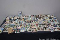 Wide view of numerous baseball cards laid out on a table showing a large lot of cards.