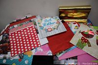 Photo showing a variety of gift bags in mixed designs and colors including polka dot, floral, holiday, and metallic finishes.