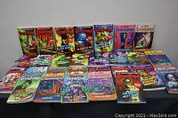 Photo showing 23 Goosebumps paperback books by R.L. Stine arranged on table, visible wear on covers.
