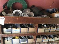 Wooden shelving with top and lower shelves filled with cardboard boxes of assorted electrical parts