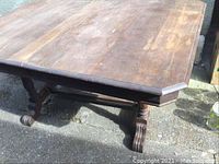 Photo showing the detached rectangular wooden table top with a dark finish, displaying surface wear and some light damage.