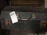 Closed black metal toolbox with carry handle and two latch closures shown from above.