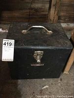 Closed black metal carrying case with handle and latch, labeled as circular saw case.