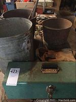 Three buckets and green toolbox on workbench