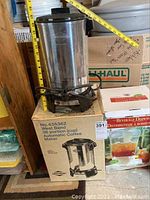 West Bend 30-Cup Coffee Urn on its original box with measurement tape showing height.