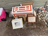 Closed wooden box with orange-red geometric exterior accents packed among stone landscape and other boxes