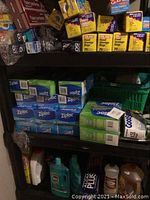 Shelf stocked with multiple boxes of Ziploc storage bags and cleaning supplies including Vim cleaner and Murphy Soap bottles on bottom shelf.