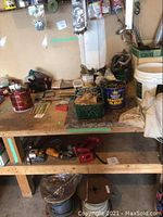 Workbench with assorted hardware items and two power tools underneath