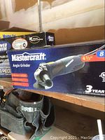 Photo of a Mastercraft 4.5 inch angle grinder box with product details and warranty info.