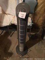 Full front view of the tower fan showing vertical grille and base.