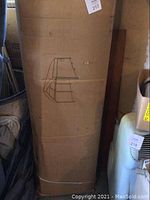 Corrugated cardboard box with line drawing of steel canopy garage on side