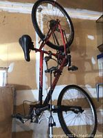 Full side view of red Norco bicycle hanging vertically