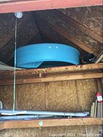 Blue circular pool stored on a shelf, showing side view.