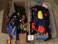 Two storage bins containing Nerf guns, foam darts, foam balls and a box with Hot Wheels cars and track pieces.