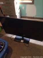 Panasonic 50 inch TV front view with remote on base, showing overall item layout.