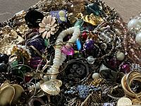 Close-up view of assorted jewelry showing a variety of colors, materials, and styles including beads, rhinestones, and metal chains.
