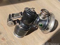 Side profile of the black Joseph Lucas King of the Road carbide lamp with clamp mount showing top cap, valve and mounting hardware