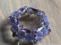 Top angle showing purple rhinestones arranged circularly on the brooch.